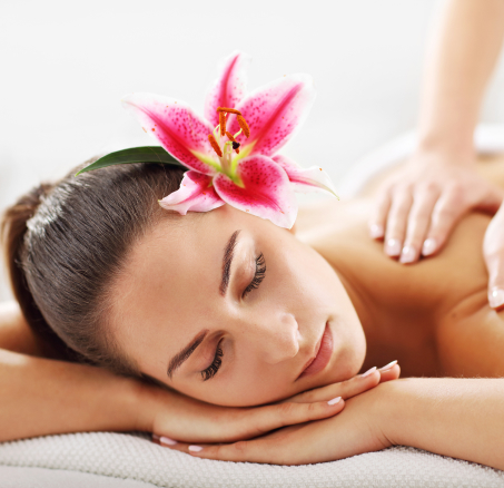 Woman receiving massage with flower in hair.