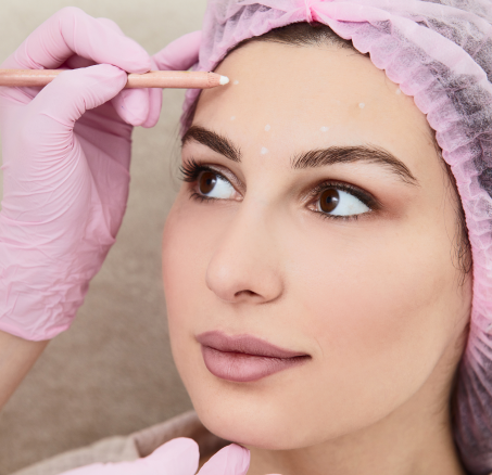 Woman receiving cosmetic treatment, face marked.