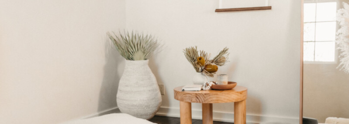 Minimalist room with wooden table and vase.