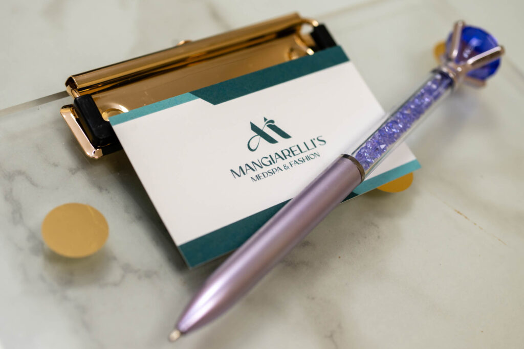Pen and business card on clipboard.