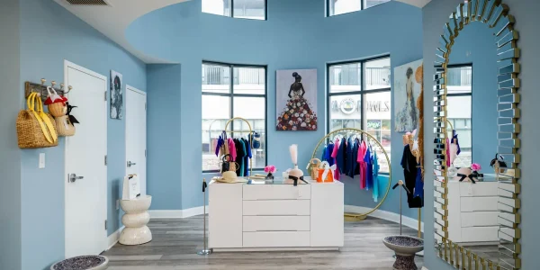 Boutique interior with clothing and large mirror.