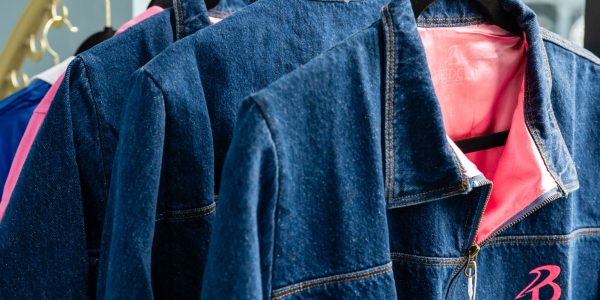 Denim jackets with pink lining on hangers.